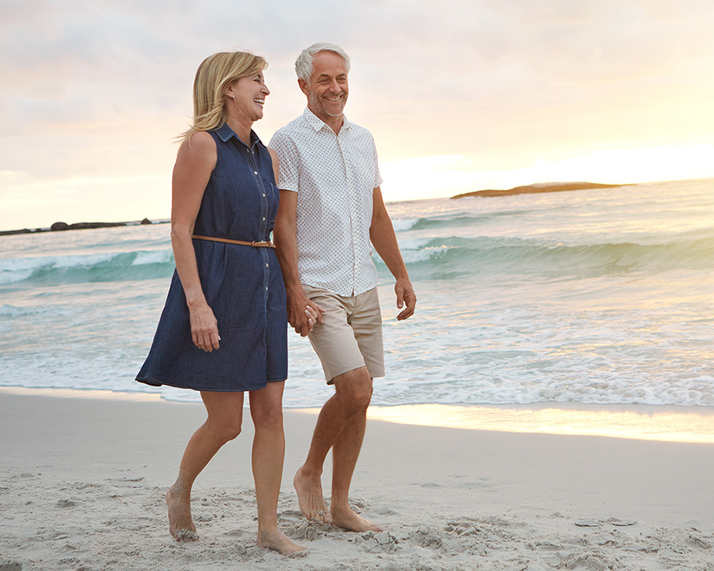 happy couple walking on the beach